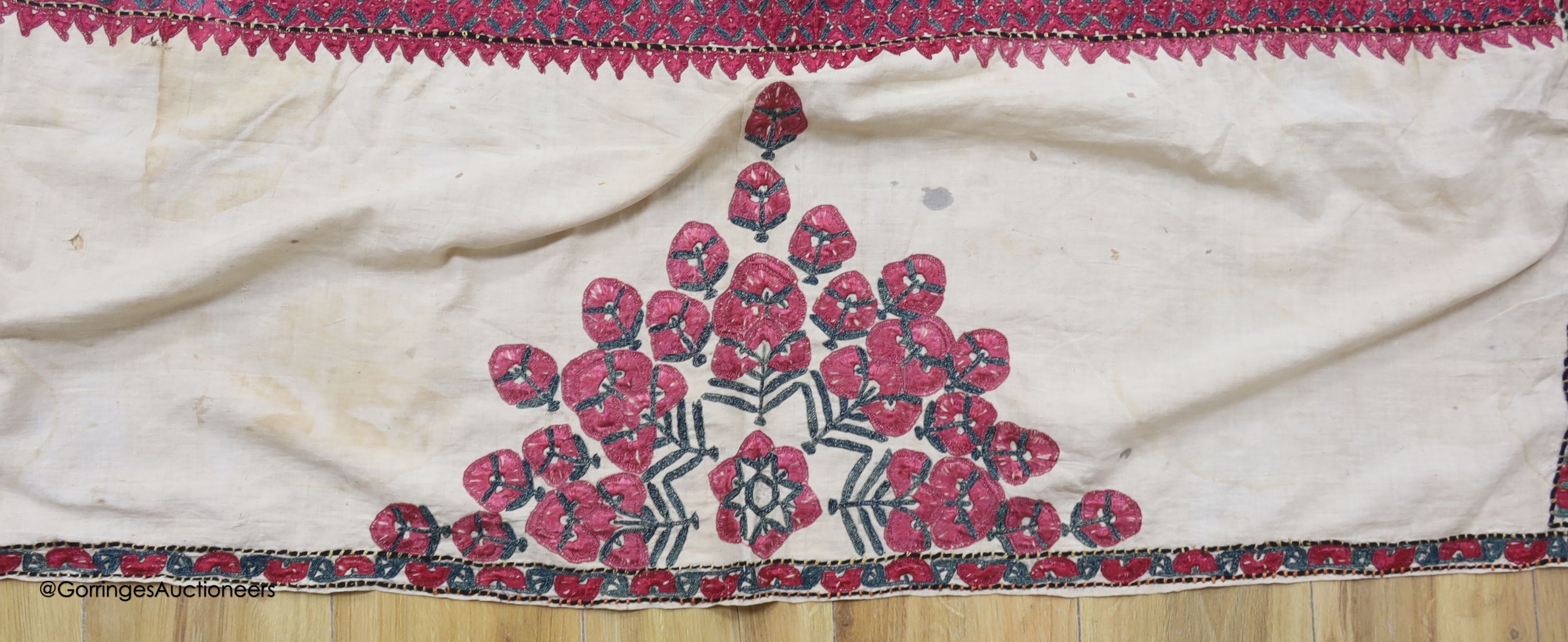 A silk embroidered Suzani, embroidered with cherry red flower heads with green stems and leaves in fine silk, width 134cm length 220cm